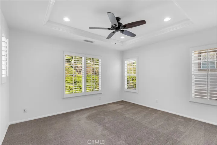 Master bedroom with plantation shutters, recessed lighting, ceiling fan