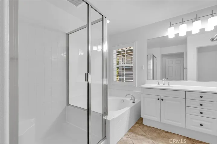 Master Bathroom with dual vanities, seperate bathtub + step-in shower.\