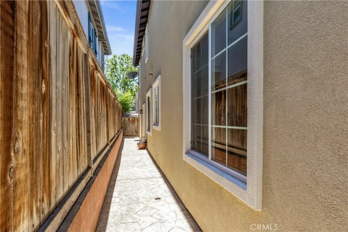 Pathway behind home wraps around past garage to side fence