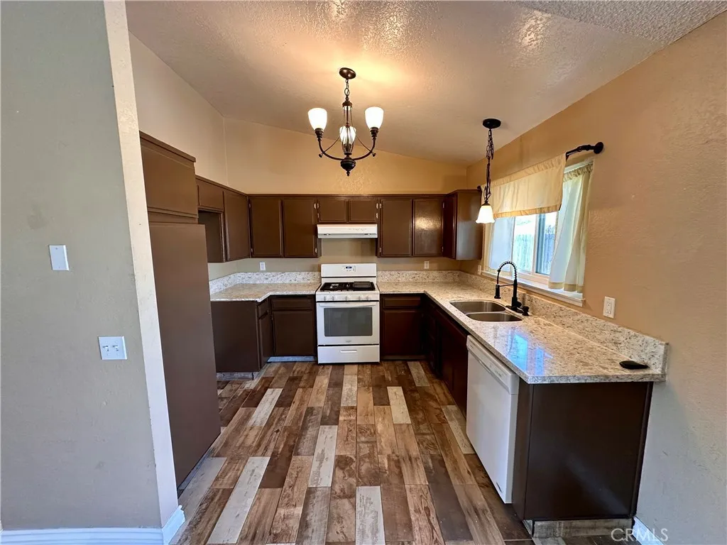 The kitchen offers abundant cabinetry, generous counter space, a gas range, double-basin sink, and a window that brings natural light into the workspace. The kitchen offers abundant cabinetry, generous counter space, a gas range, double-basin sink, and a window that brings natural light into the workspace.