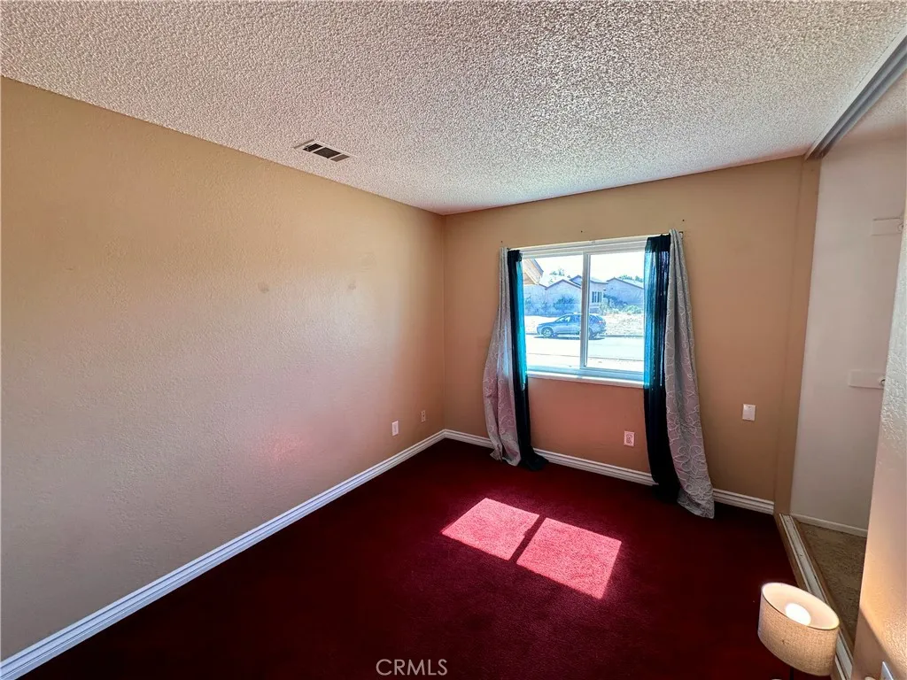 A bright bedroom offers a front-facing window, ample wall space, and rich carpeting for a warm, comfortable setting. A bright bedroom offers a front-facing window, ample wall space, and rich carpeting for a warm, comfortable setting.