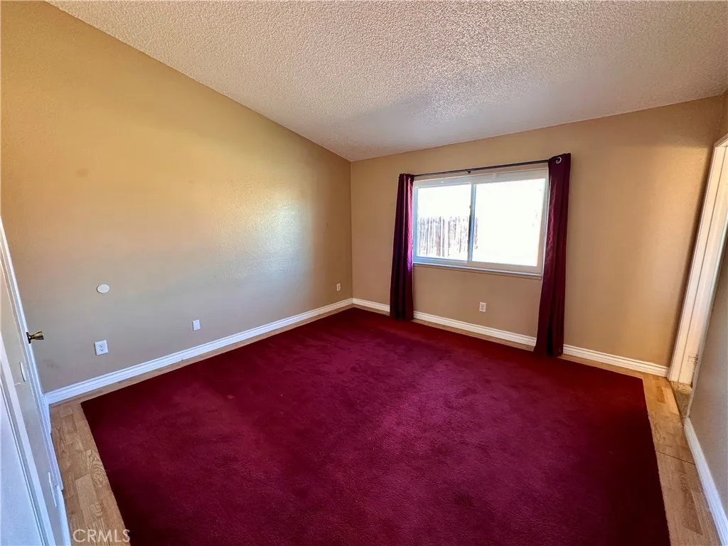 This spacious bedroom includes a wide window, substantial floor space, neutral wall tones, and carpeting. This spacious bedroom includes a wide window, substantial floor space, neutral wall tones, and carpeting.