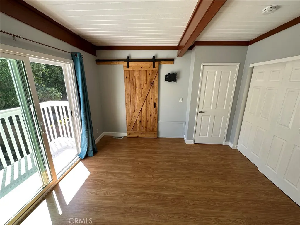 Main bedroom with barn door to bathroom and lots of closet space. Also has deck over backyard