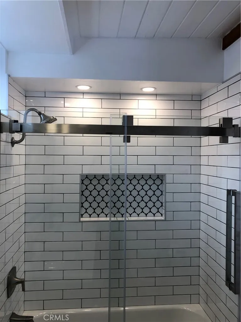 Main level bathroom with beautiful tile work in shower