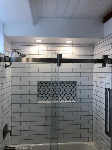 Main level bathroom with beautiful tile work in shower