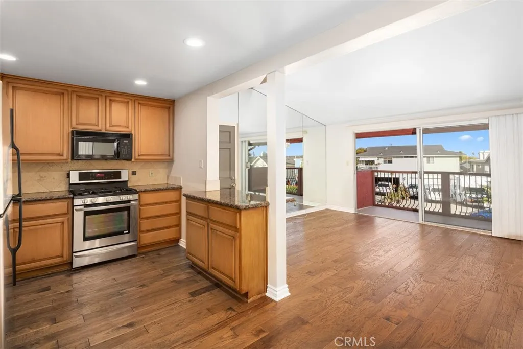 Open floor plan, wood flooring, mirrored living room wall.
wood flooring