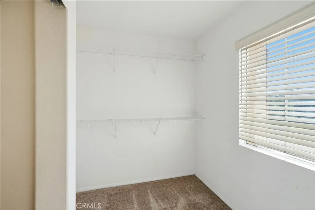 Primary closet with a window Primary closet with a window