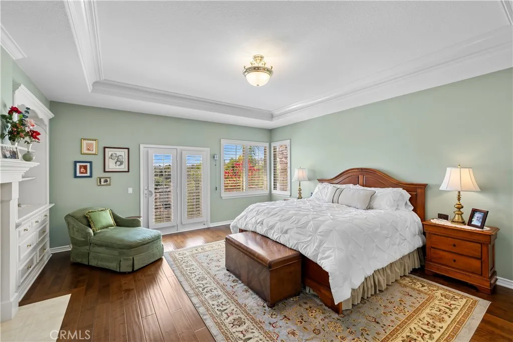 Stunning Primary Suite with Exquisite Crown Molding, Plantation Shutters, Custom Built-In's and Elegant Fireplace. Stunning Primary Suite with Exquisite Crown Molding, Plantation Shutters, Custom Built-In's and Elegant Fireplace.