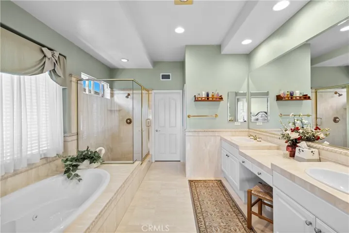 Primary Suite Opens to a Luxurious Primary Bathroom Accented in Elegant Stone for the Dual Vanity, 
Jetted Spa Tub, Shower and Flooring.