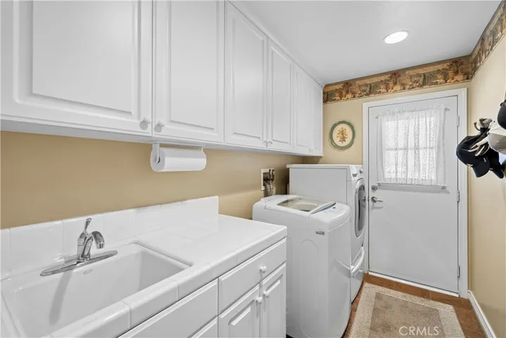 Lovely Laundry Room on Main Floor with Sink and Cabinetry.
