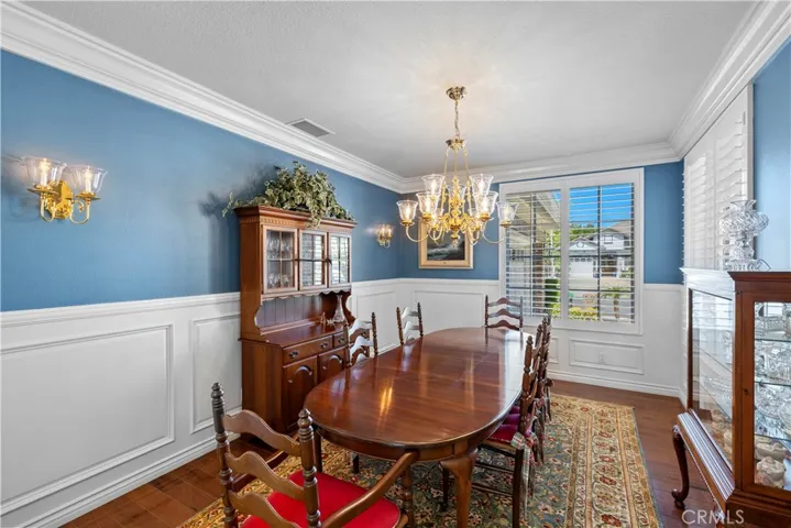 Stunning Formal Dining Room with Gorgeous Crown Molding, Intricate Wainscoting and Beautiful Plantation Shutters.