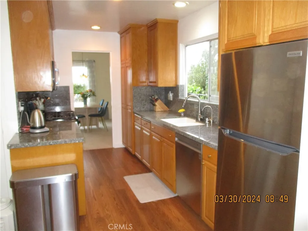 Kitchen with extensive upgrades to floors, granite counters and appliances Kitchen with extensive upgrades to floors, granite counters and appliances
