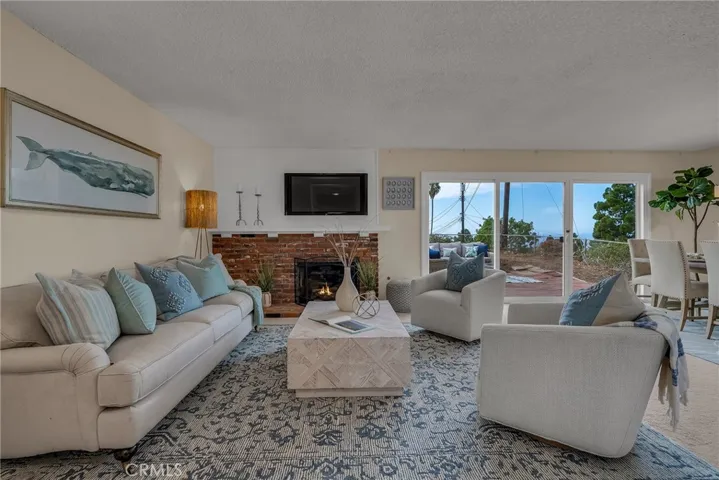 Living room with fireplace and direct access to rear patio and large grassy yard