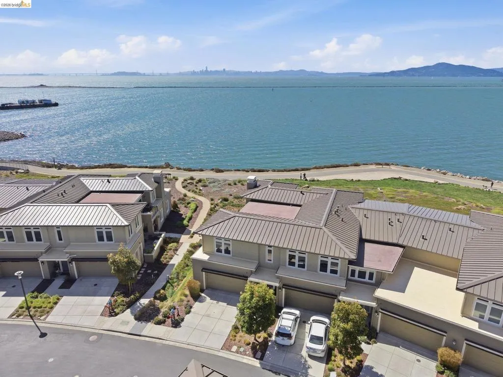 Waterfront property with multiple residential structures, pathways, and landscaping