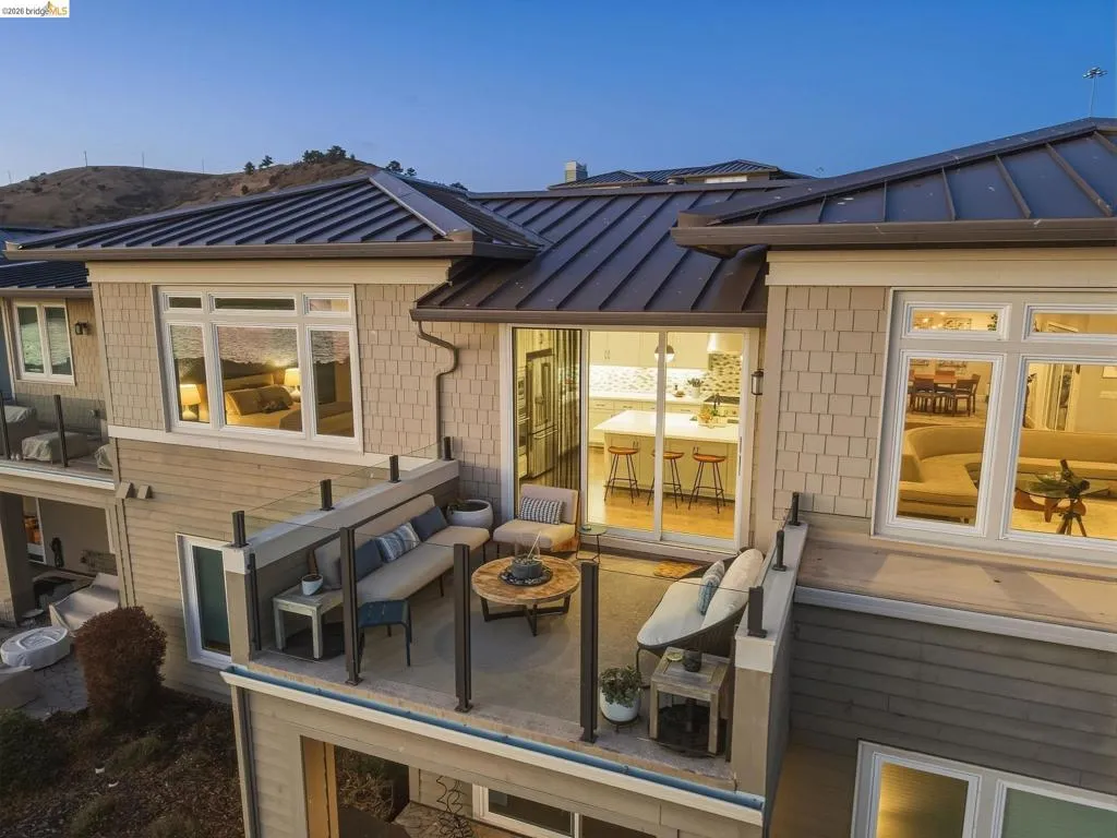Multi-level exterior with shingle siding and a dark metal roof