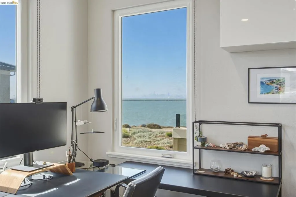 Expansive window offering water and distant city views