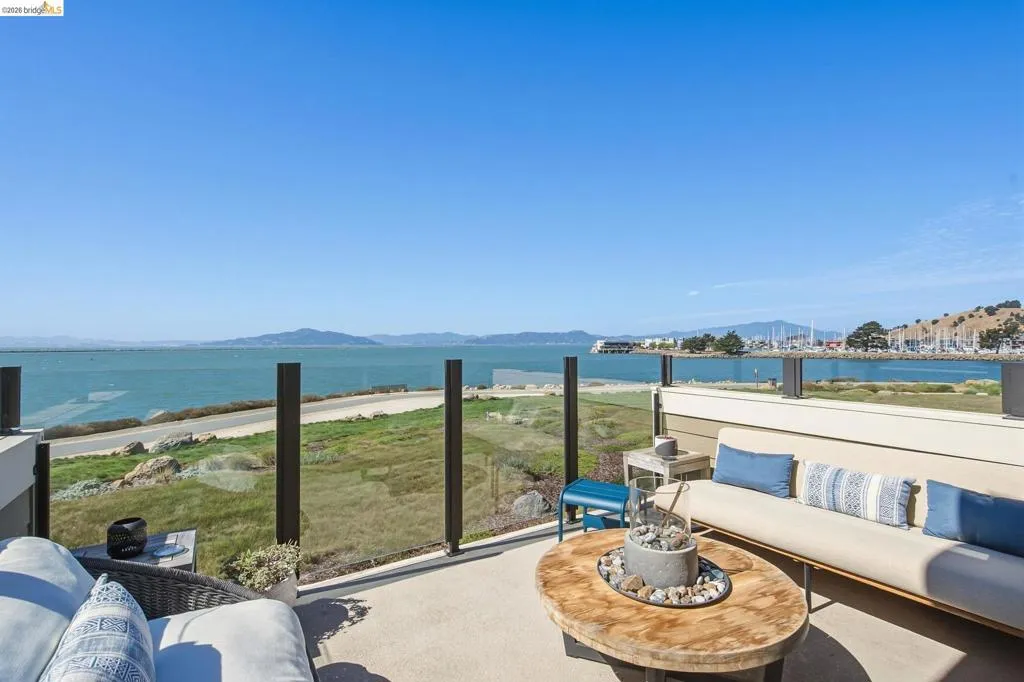 Outdoor patio with a glass railing, offering expansive water and marina scenery
