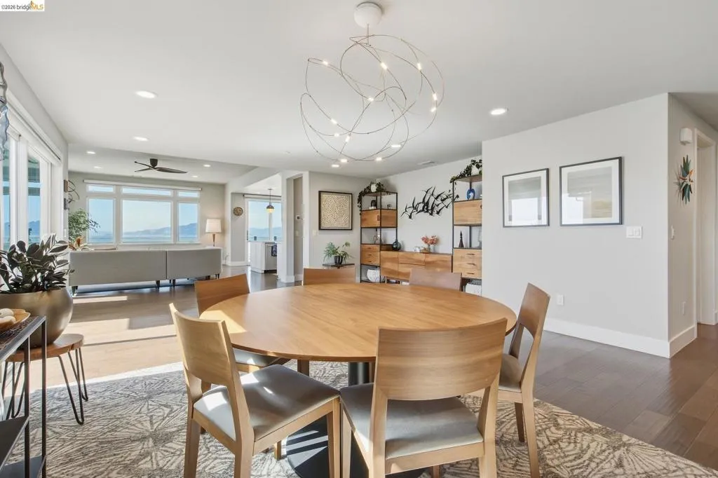 Recessed lighting, wood-finish flooring, and a modern sculptural chandelier