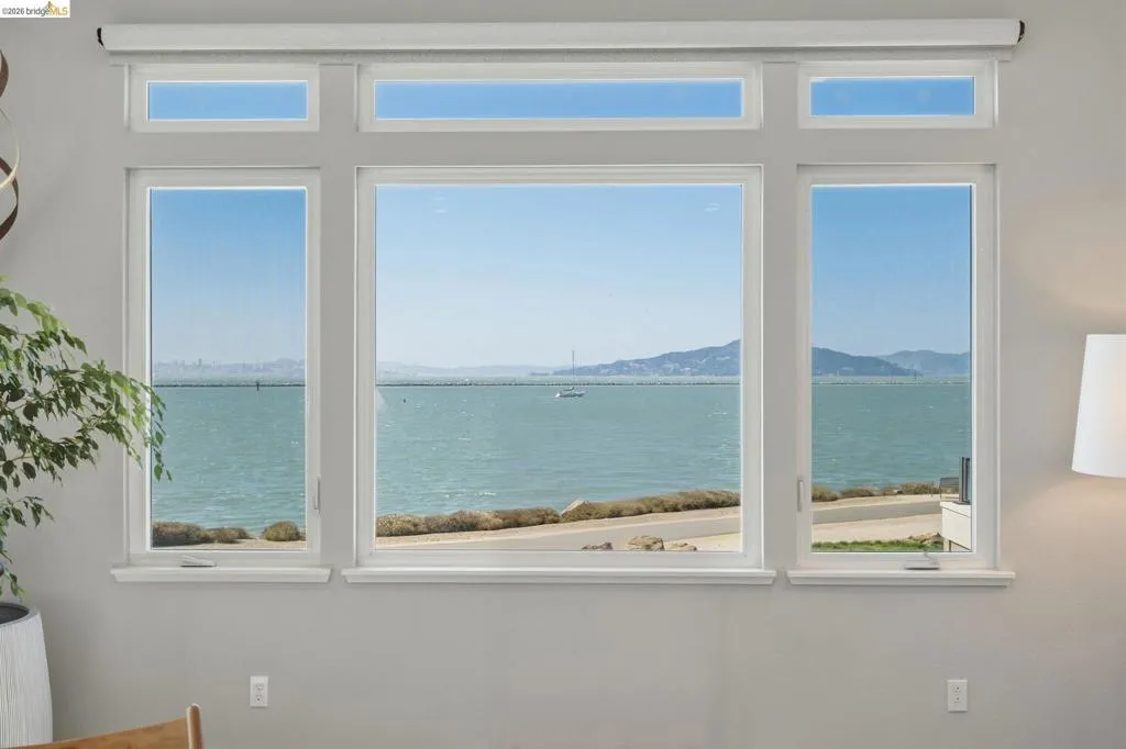 Expansive window wall with multiple panes, white trim, and roller shades