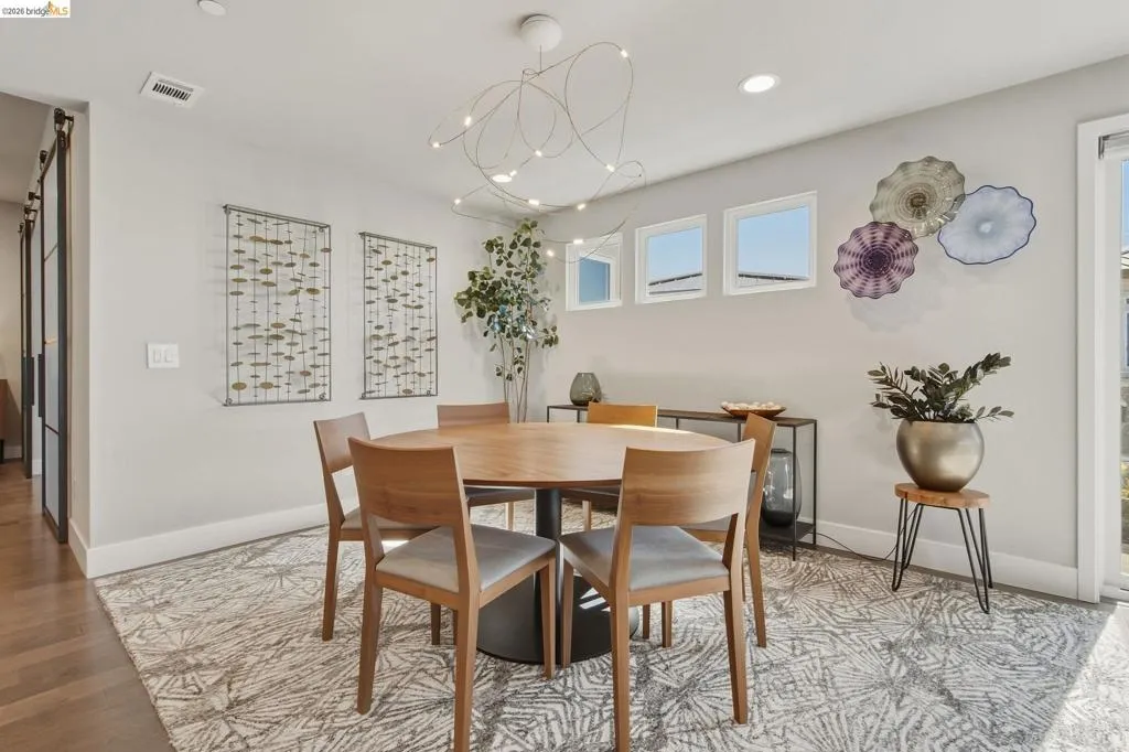 Wood-finish flooring, white baseboards, and a contemporary ceiling light fixture