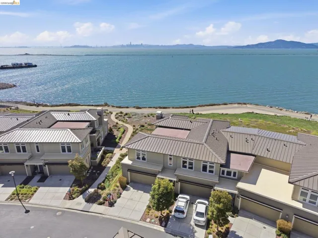 Waterfront property with multiple residential structures, pathways, and landscaping