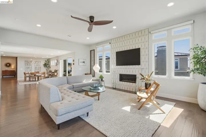 Open-concept living space with wood-finish flooring, recessed lighting, and a modern ceiling fan