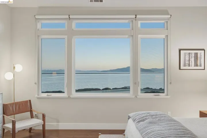 Expansive multi-pane window system with water and distant landscape scenery