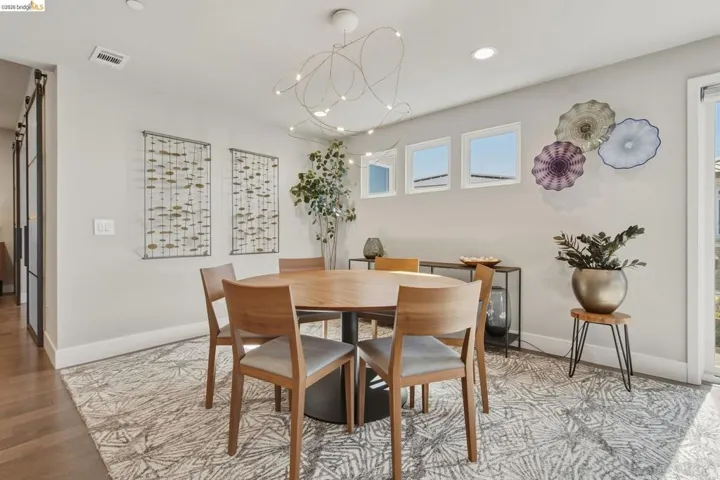 Wood-finish flooring, white baseboards, and a contemporary ceiling light fixture