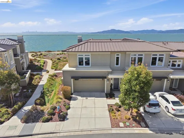 Contemporary exterior with a metal roof, attached garage, and waterfront proximity