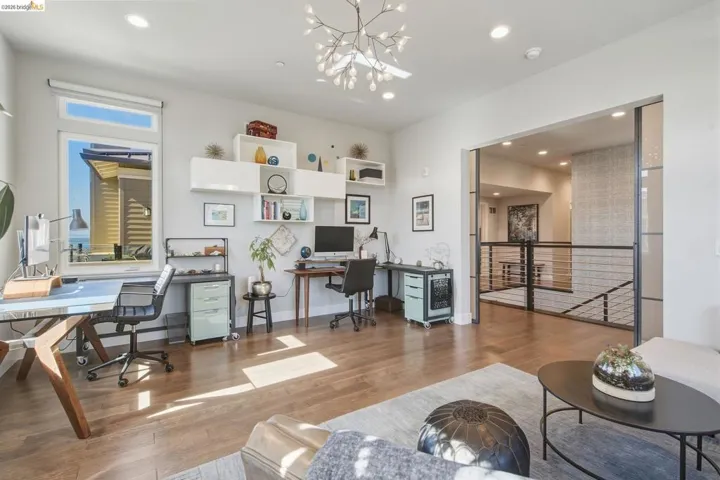 Recessed lighting, wood-finish flooring, built-in shelving, and a decorative ceiling fixture