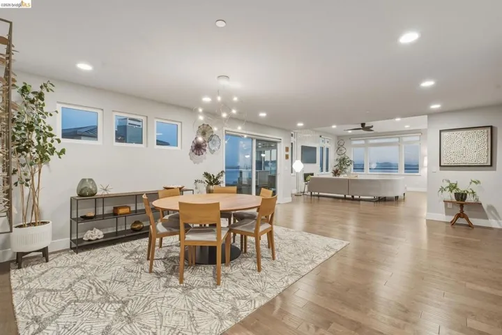 Open-concept living area featuring light wood-finish flooring, recessed lighting, and expansive windows