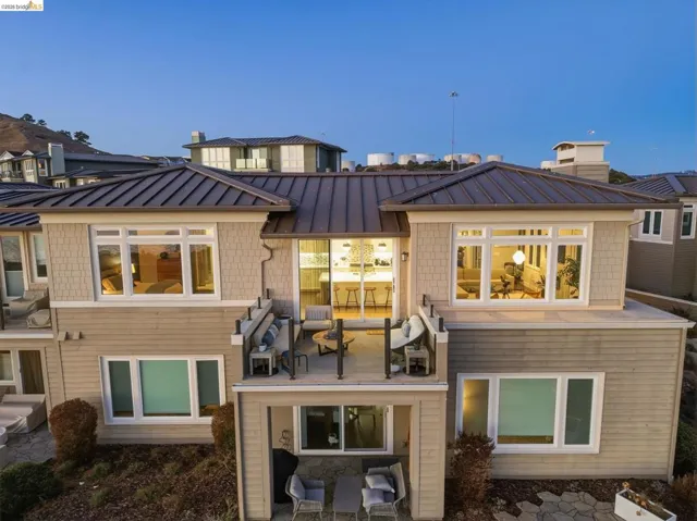 Multi-level exterior featuring a metal roof, shingle siding, and a private balcony