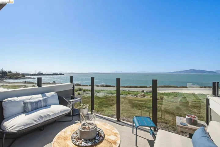 Outdoor patio with glass panel railing and water frontage