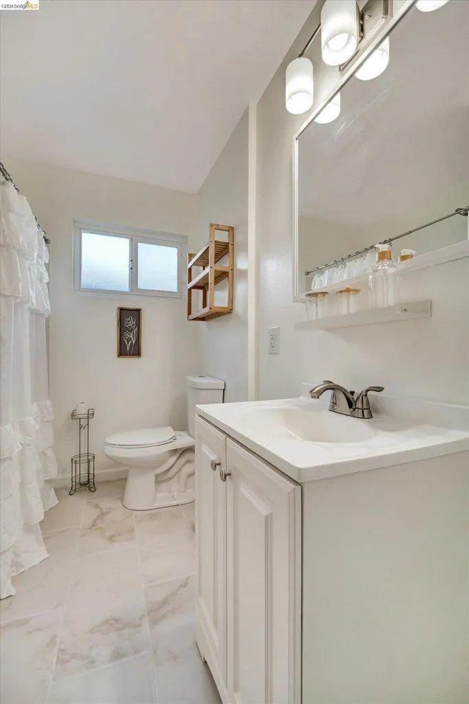 White vanity with brushed nickel hardware, integrated sink, and brushed nickel faucet