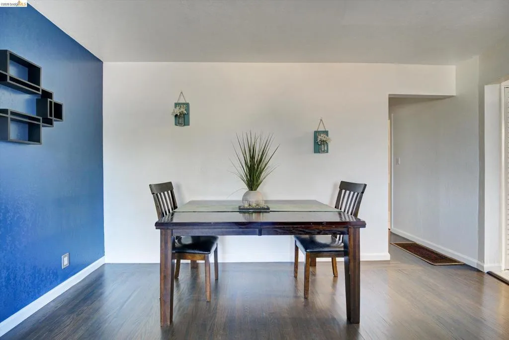 Wood-finish flooring throughout, complemented by a vibrant accent wall and recessed entryway