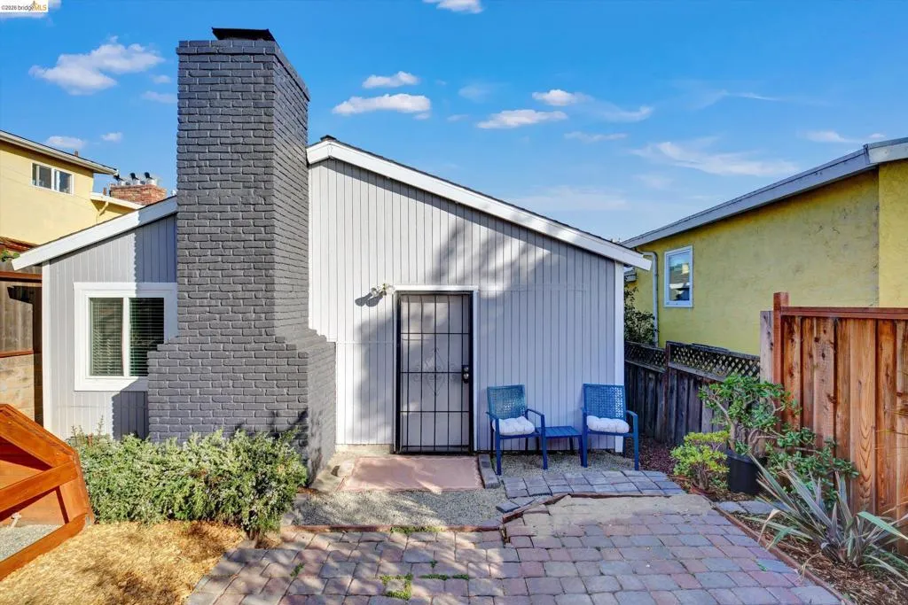 Vertical siding exterior with a painted brick chimney