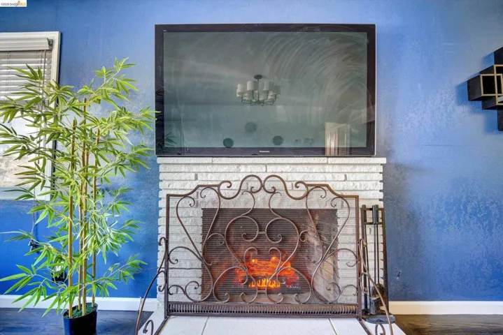 Fireplace with a white brick surround, hearth, and ornate metal screen