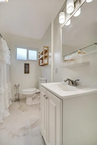 White vanity with brushed nickel hardware, integrated sink, and brushed nickel faucet