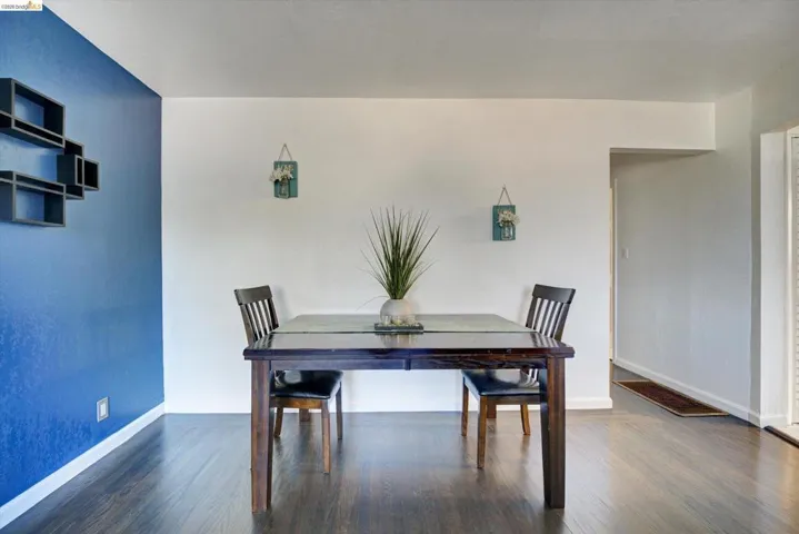 Wood-finish flooring throughout, complemented by a vibrant accent wall and recessed entryway