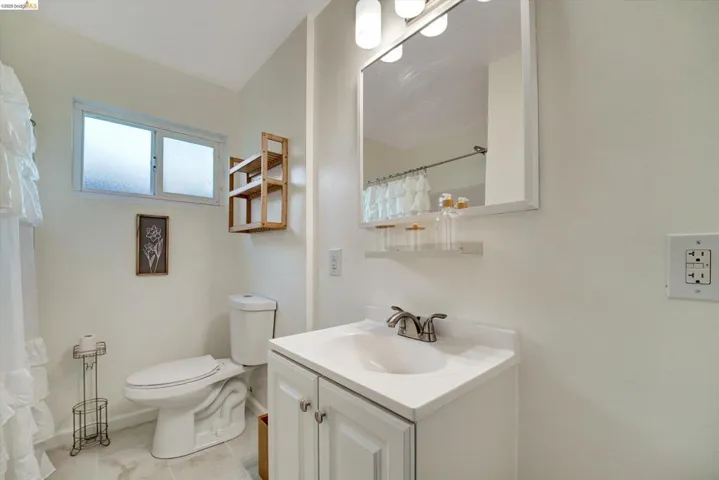 White vanity with integrated sink, chrome faucet, and framed mirror