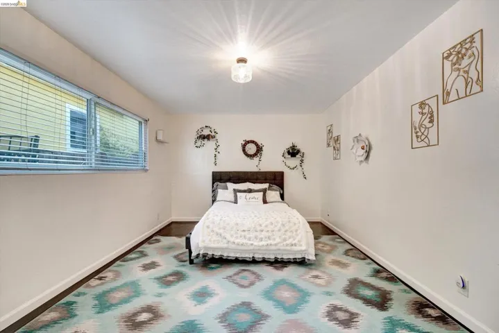 Recessed lighting, window with blinds, dark wood-finish flooring, and white painted walls