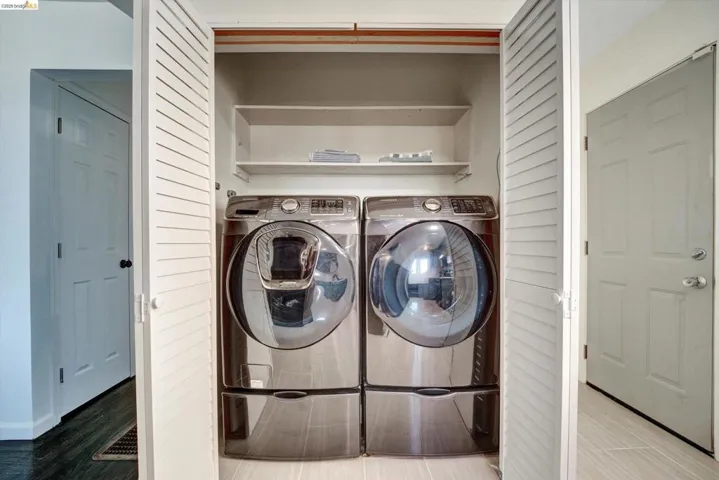 Recessed laundry closet with louvered bi-fold doors and integrated shelving