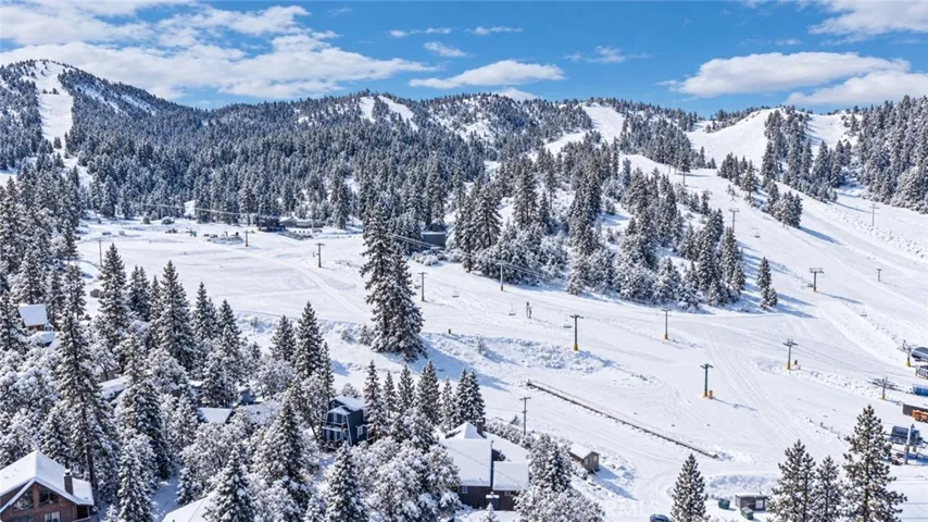 Slope's steps from your door. Snow added by AI.