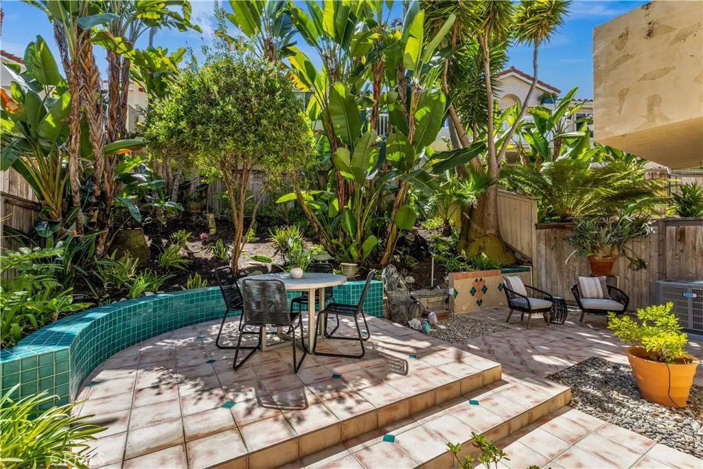 The large backyard has tropical landscaping throughout.