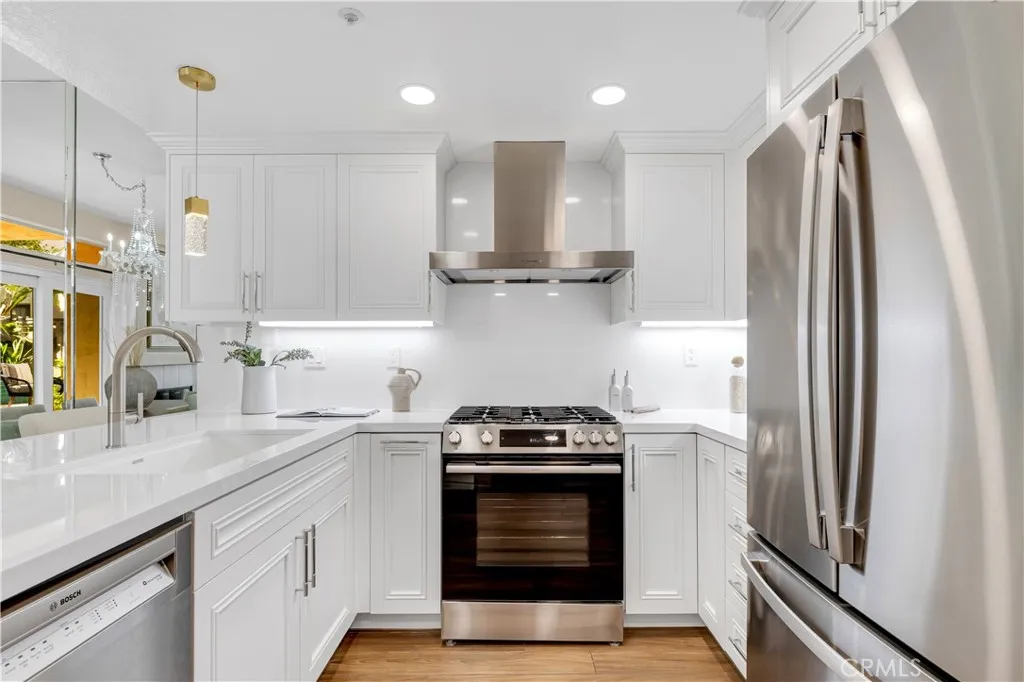 The chef's kitchen features brand new countertops, backsplash, custom cabinetry, stainless steel Bosch appliances, pendant lights and more.