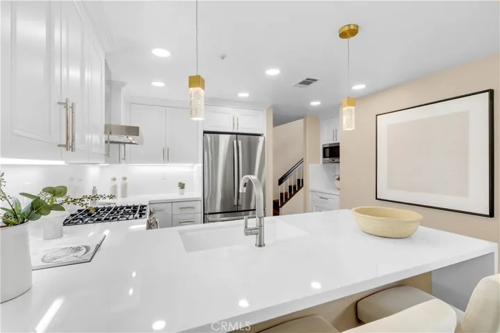 The quartz countertop feature a bartop eating area as well as a waterfall edge.