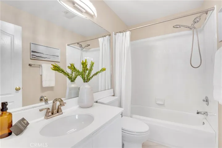 The upstairs guest bathroom has an upgraded countertop, faucet hardware and light fixture.