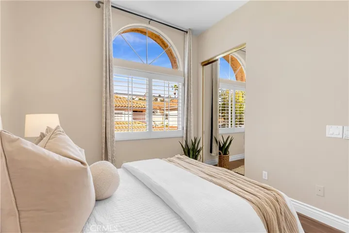 The guest bedroom has a ceiling fan as well as a mirrored closet.