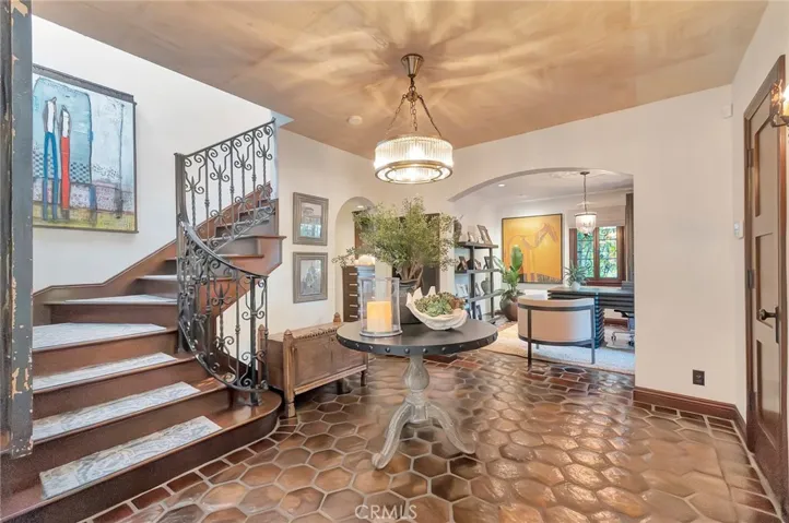 A foyer of grandeur- as seen thruout the home- Terra-cotta floors and wood floors, period reproduction lighting of solid brass, Mahogany mill-work finished like glass.   Original doors and unique cork ceiling.    office or 4th bedroom in the far ground with bathroom adjacent.