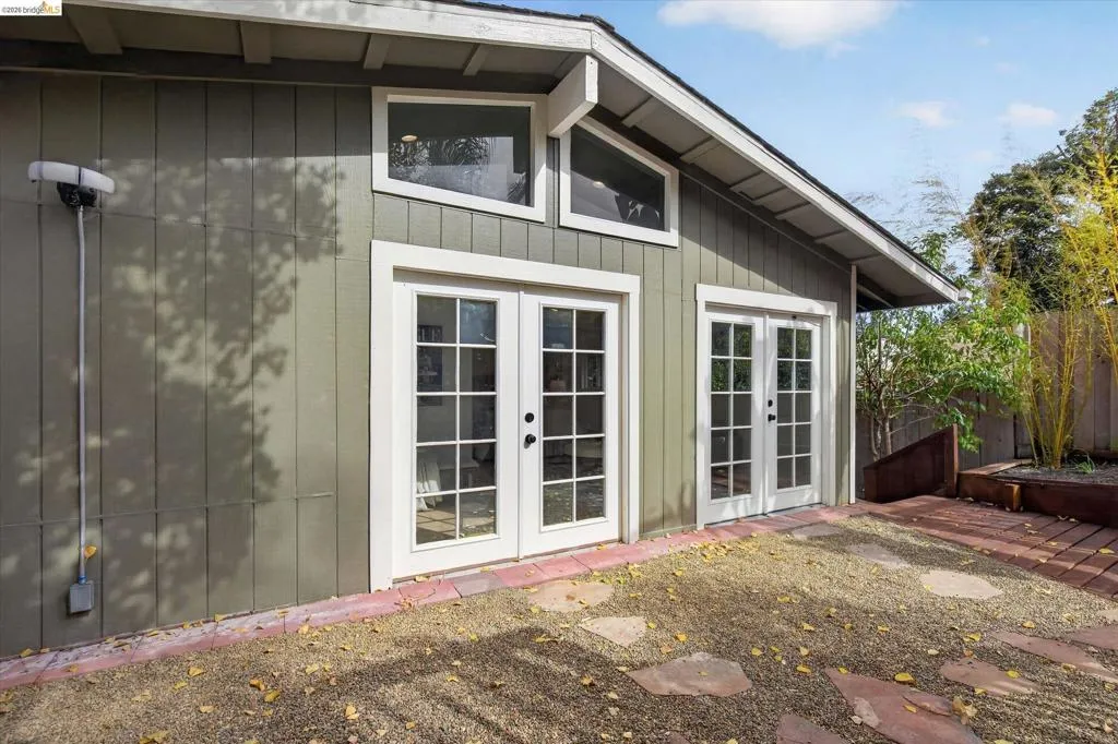 Exterior building featuring two sets of double French doors, transom windows, and board and batten siding